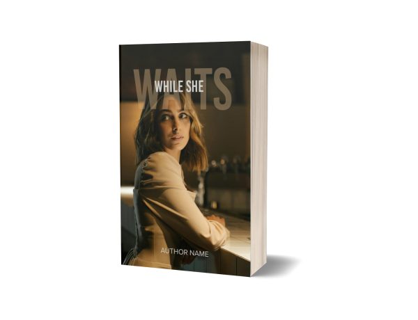 A book titled "While She Waits" features a photograph of a woman with light brown hair looking off to the side. She is wearing a beige jacket and sitting at a table in a softly lit setting. The author's name is written at the bottom. The book is positioned standing up with its pages slightly visible. BookSelf Book Cover Design & Premade Book Covers